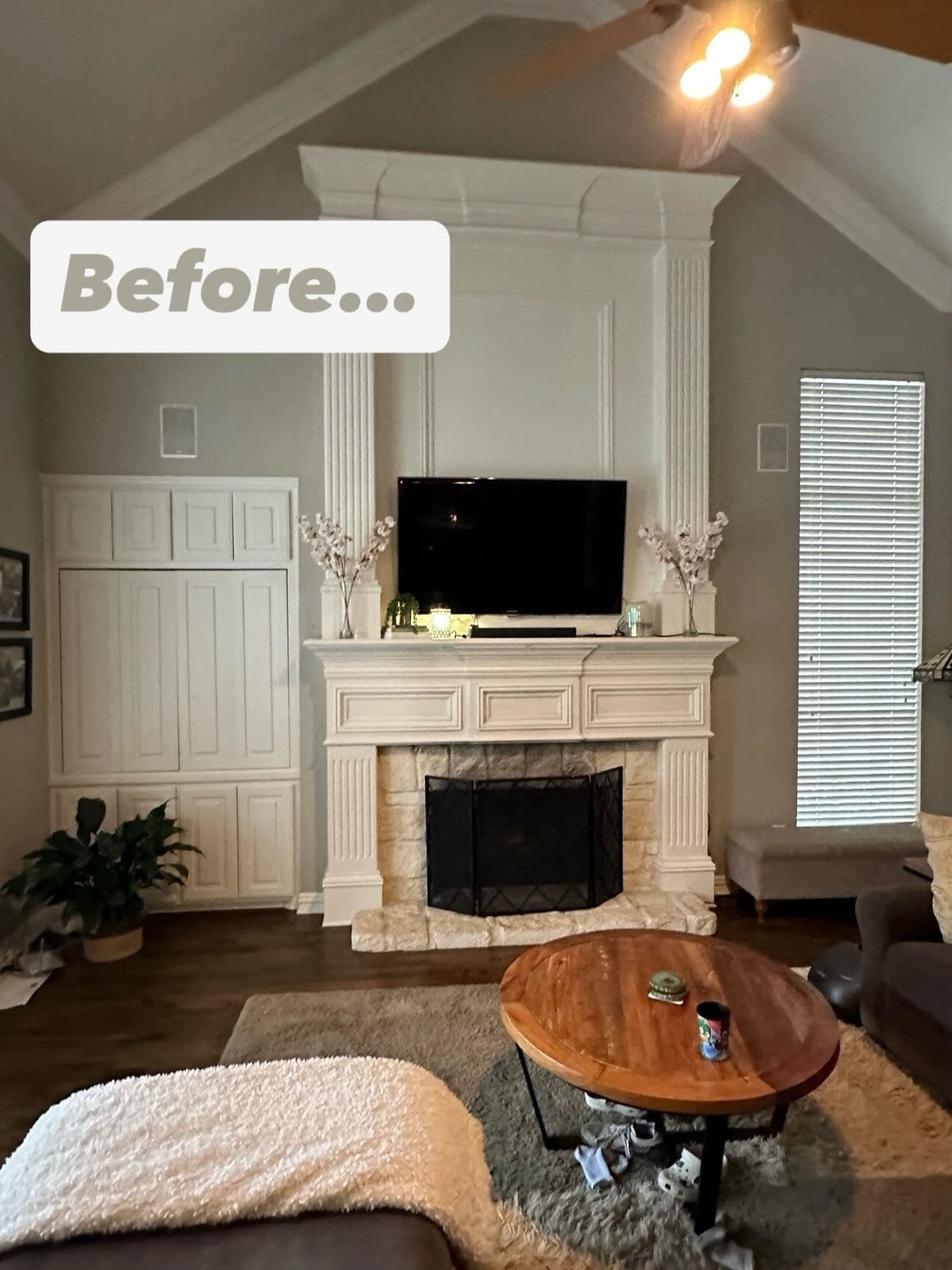 The same living room before the work, with a painted timber mantel, a tiled surround and a ceiling fan